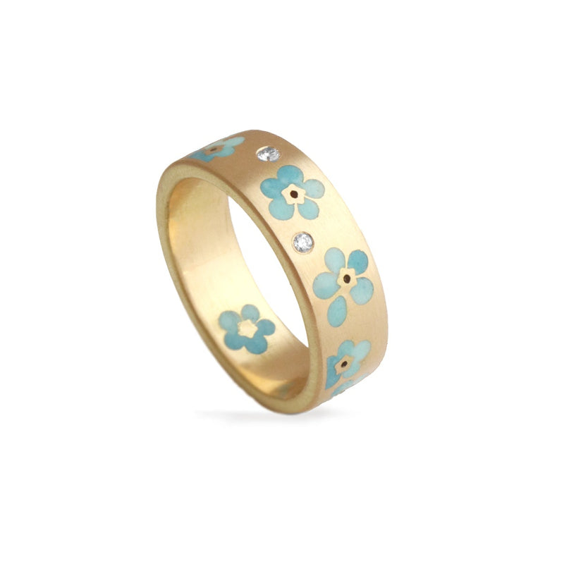 Gold ring with blue Forget me not floral designs on a white background