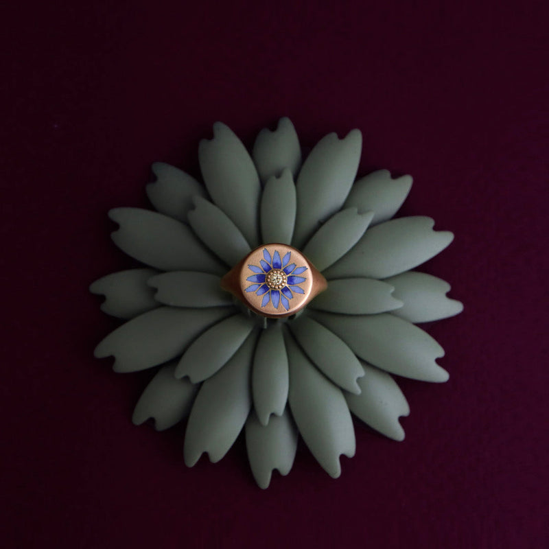 Floral ring with blue gemstone on a dark background