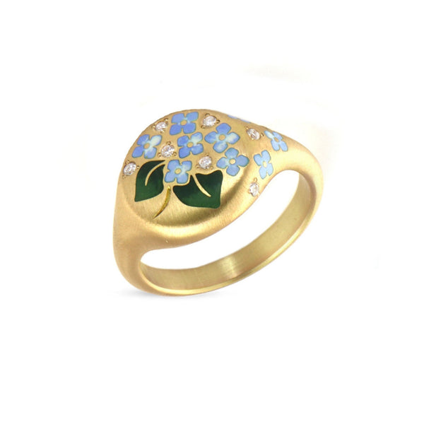 Gold ring with blue enamel floral design on a white background