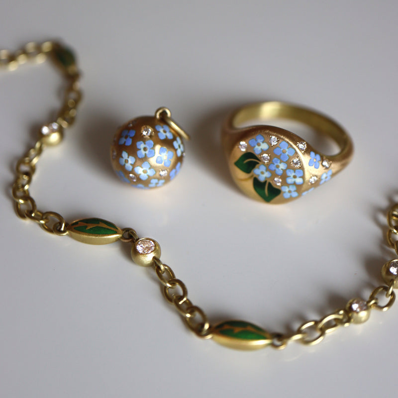 Gold floral jewelry set with a ring and bracelet on a light gray background
