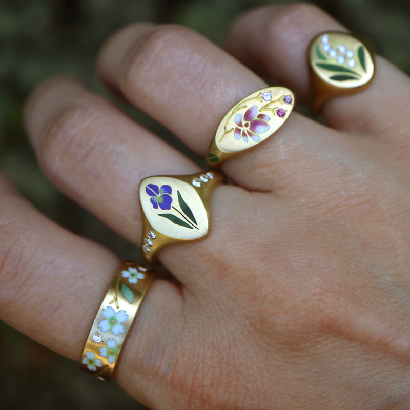 enamel rings with floral designs on a hand