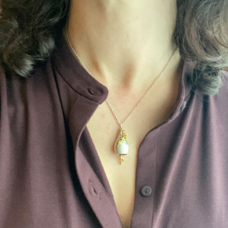 Fine jewelry bell pendant on model's neck