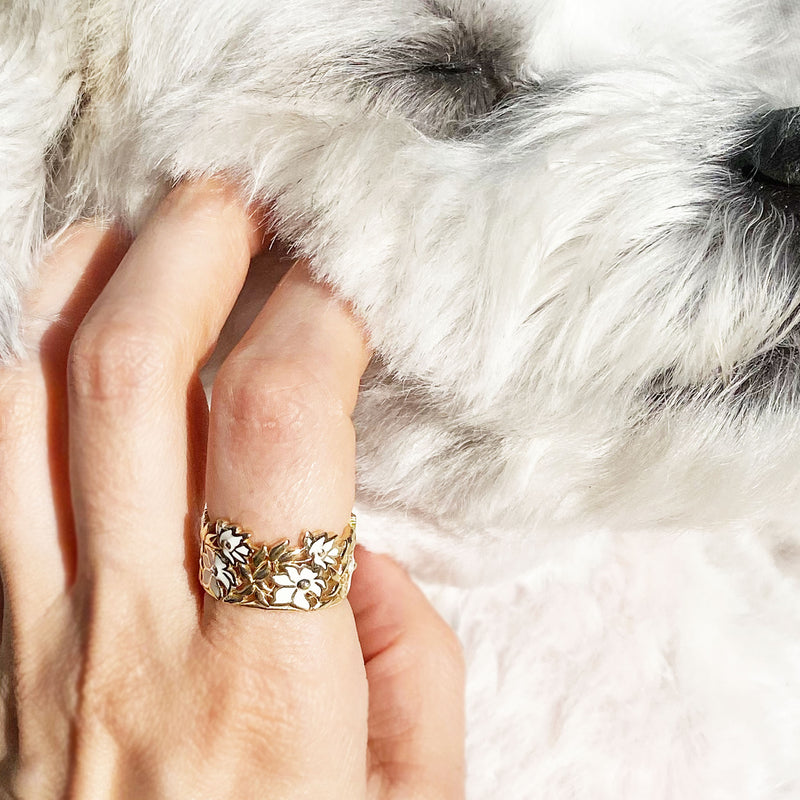 White Floral Enamel Ring on a Hand Petting a Cute White Puppy